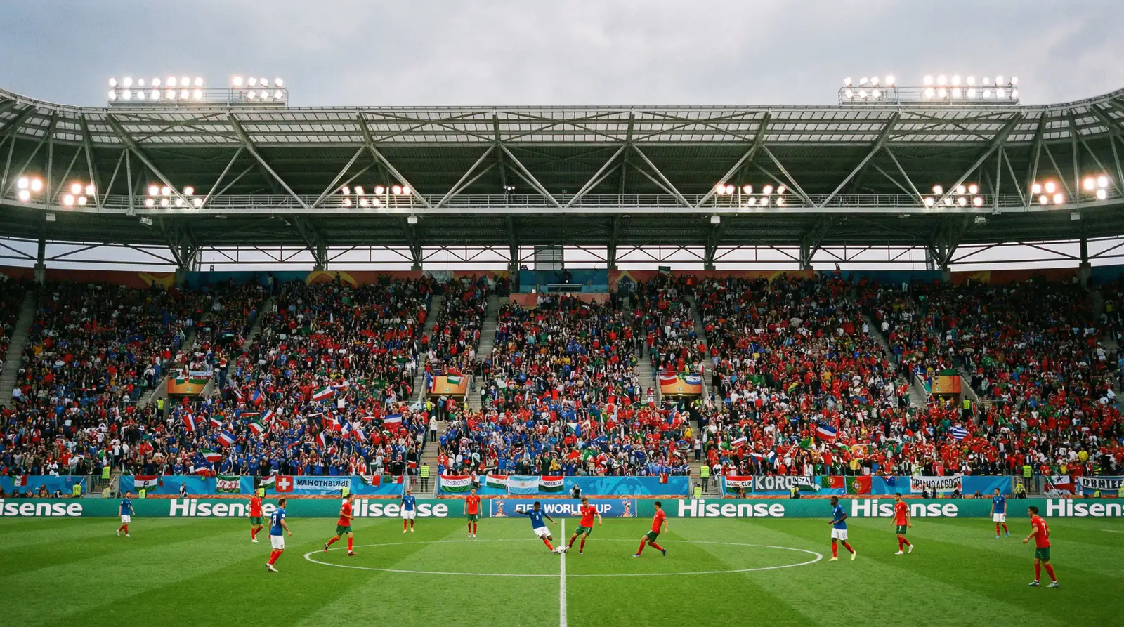 Gradas de un estadio repletas de aficionados con banderas de distintos países durante un partido de fase de grupos